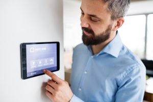Man-using-smart-thermostat-at-home